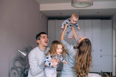 Aile yatak odasında oyun oynuyor.