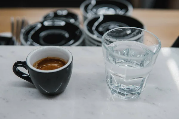 Kopje met koffie bij een glas water — Stockfoto