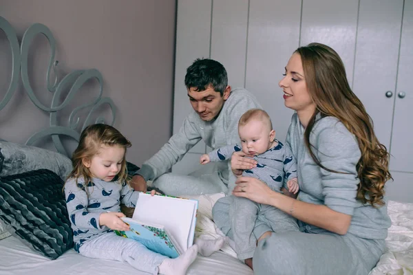 Familjen leker på sängen i sovrummet — Stockfoto