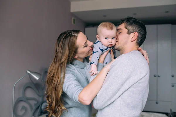 Familia jugando en la cama en el dormitorio — Foto de Stock