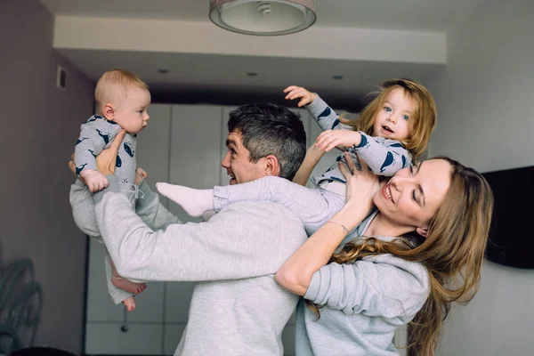 Familia jugando en la cama en el dormitorio — Foto de Stock