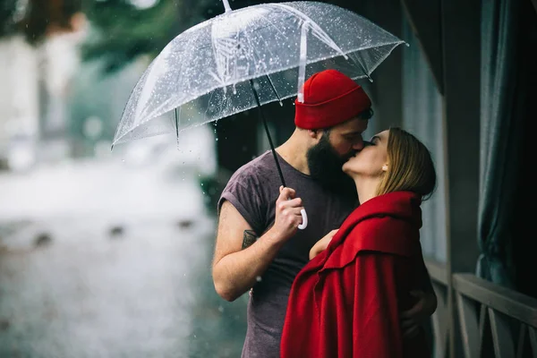 Guy and the girl kissing under an umbrella — Stock Photo, Image