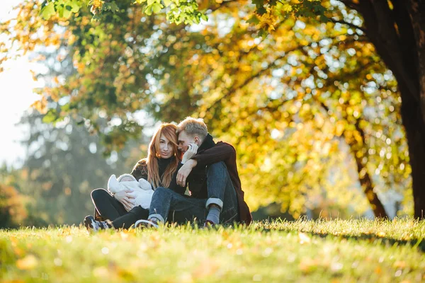 Junge Familie mit neugeborenem Sohn im Herbstpark — Stockfoto