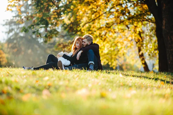 Junge Familie mit neugeborenem Sohn im Herbstpark — Stockfoto