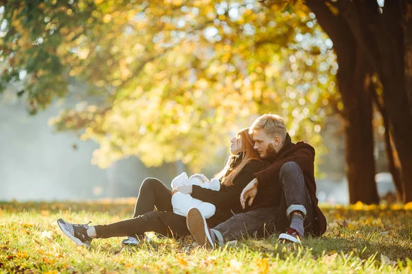 Young family and newborn son in autumn park — Stock Photo, Image