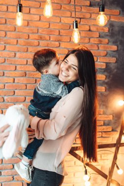 Anne ve küçük oğlu telefon başında poz veriyor.