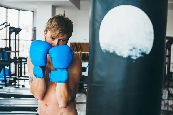 Boxeador con saco de boxeo en gimnasio — Foto de Stock