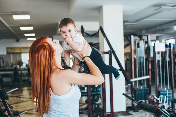 Joven madre con su hijo pequeño en el gimnasio — Foto de Stock