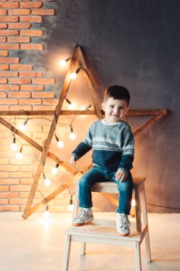 Küçük çocuk sandalyede oturuyor.