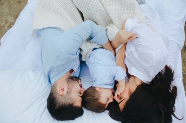 Mutlu aile yatakta birlikte dinleniyor.