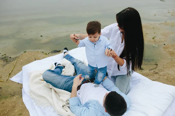 Jovem família feliz relaxando juntos no lago — Fotografia de Stock