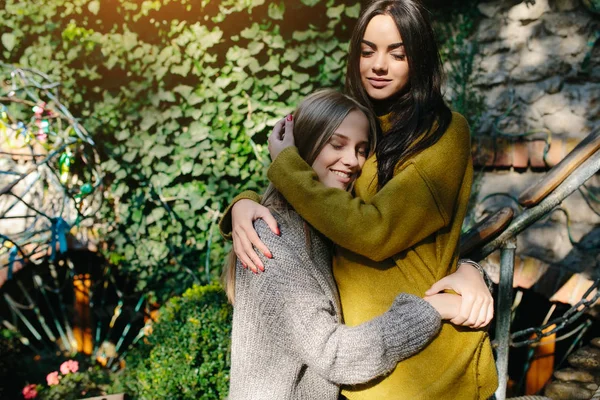 Twee meisjes knuffelen in de schaduw van de bladeren — Stockfoto