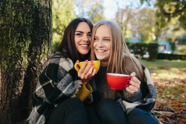 Parkta iki güzel, kameraya poz veriyorlar.