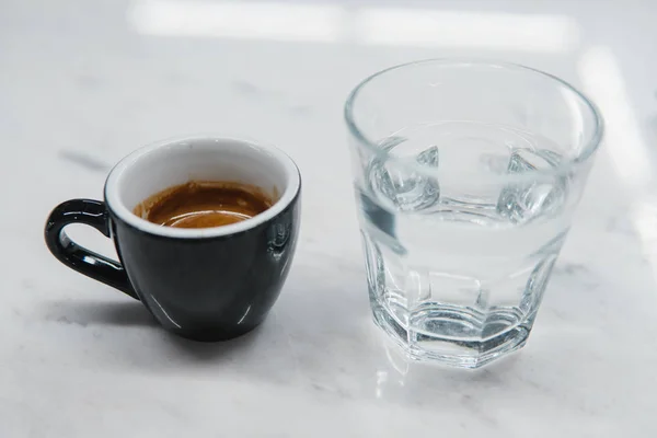 Taza con café cerca de un vaso de agua —  Fotos de Stock