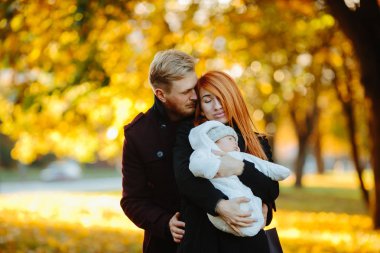 Genç aile ve sonbahar Park yeni doğan oğlu