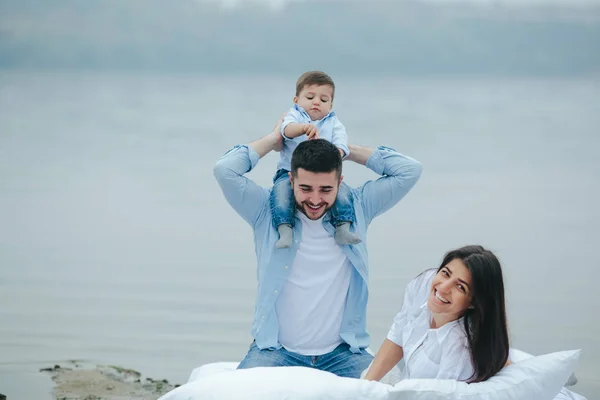 Joyeux jeune famille se détendre ensemble sur le lac — Photo