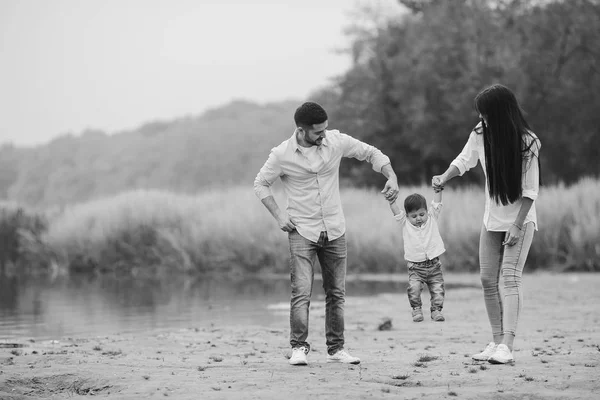 Jovem família caminhando na praia — Fotografia de Stock