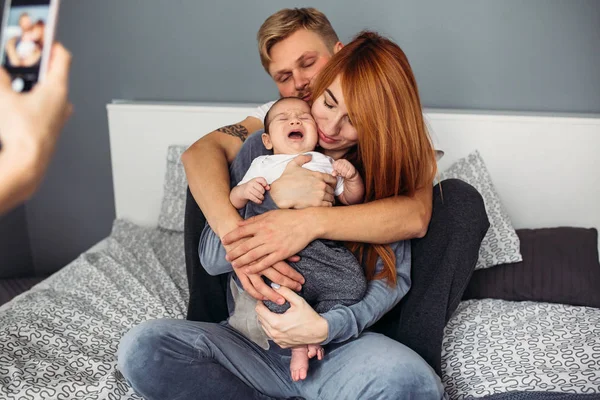 Ευτυχισμένη οικογένεια με το νεογέννητο μωρό στο κρεβάτι — Φωτογραφία Αρχείου