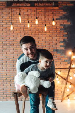 Baba ve oğul bir tuğla duvarın arkasında