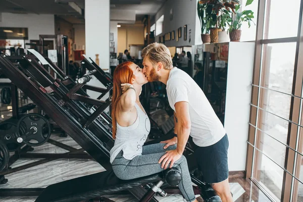 Guy kiss girlfriend on training in gym — Stock Photo, Image