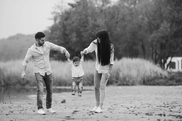 Ung familj promenader på stranden — Stockfoto