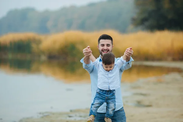 Dad holding infant sons hands — Stock Photo, Image