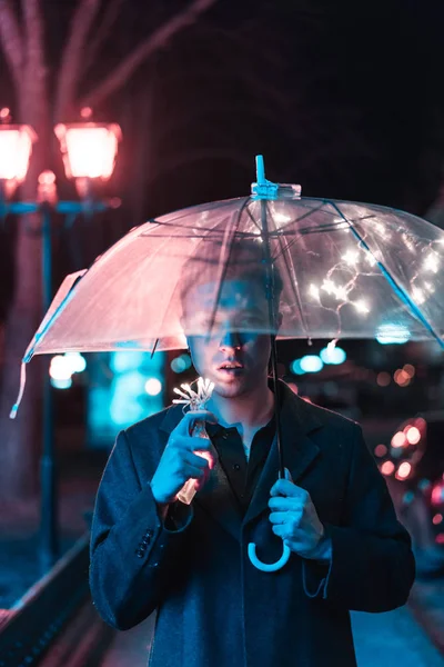 Um tipo debaixo de um guarda-chuva Imagens De Bancos De Imagens