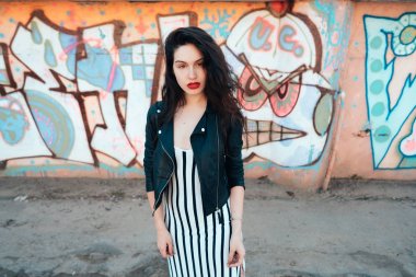 Güzel, modaya uygun bir bayan eski sokakta poz veriyor.