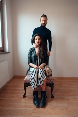 Onun arkasında duran bir sandalye adam üzerinde oturan kız