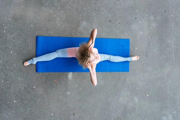 Junge schlanke blonde Frau macht Yoga-Übungen — Stockfoto