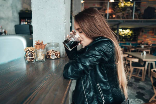 Beautiful girl in a black jacket in a cafe — Stock Photo, Image