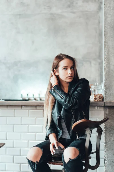 Menina bonita em uma jaqueta preta em um café — Fotografia de Stock