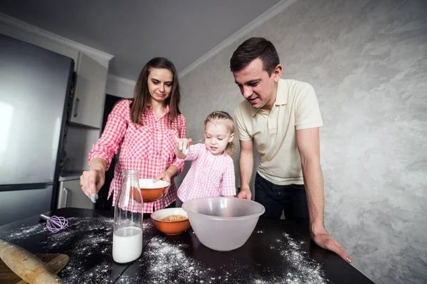 Папа, мама и дочь вместе на кухне — стоковое фото
