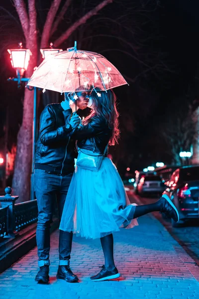 Facet i dziewczyna całowanie pod parasolem — Zdjęcie stockowe