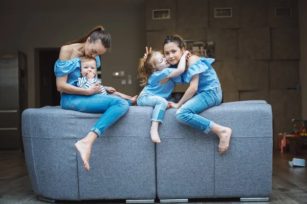 Mamá, dos hijas y un hijito en el sofá — Foto de Stock