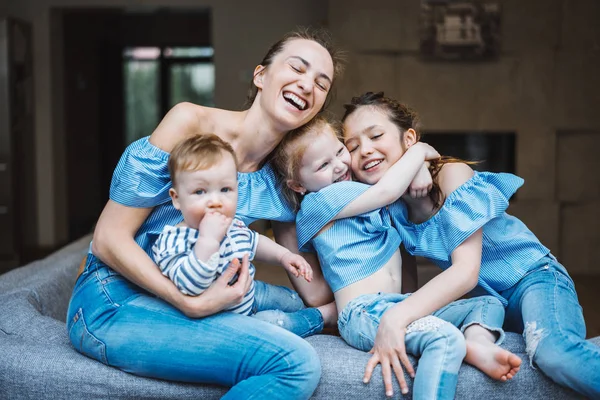 Mamma, två döttrar och en liten son på soffan. — Stockfoto