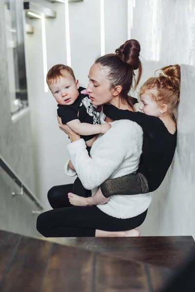 Mom and son in her arms, daughter on her back — Stock Photo, Image