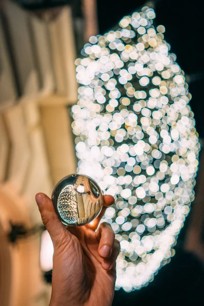 Una palla di vetro sullo sfondo di una ghirlanda — Foto Stock