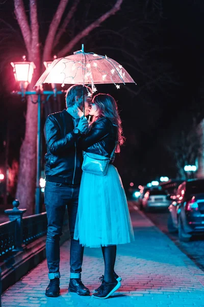 男孩和女孩在伞下接吻 — 图库照片