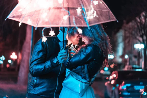 Cara e menina beijos sob um guarda-chuva — Fotografia de Stock