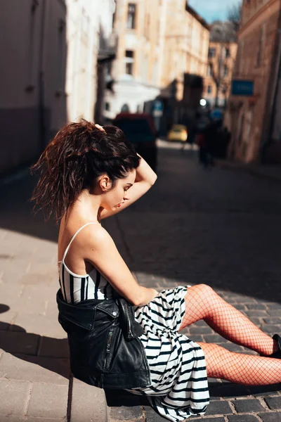 Linda senhora da moda sentada na rua velha — Fotografia de Stock