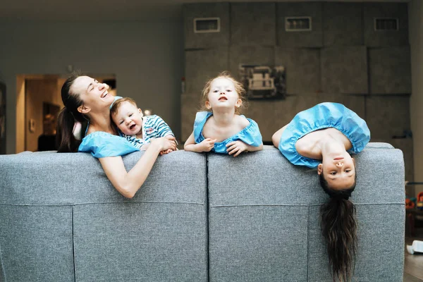 Ibu, dua anak perempuan dan seorang anak kecil di sofa — Stok Foto