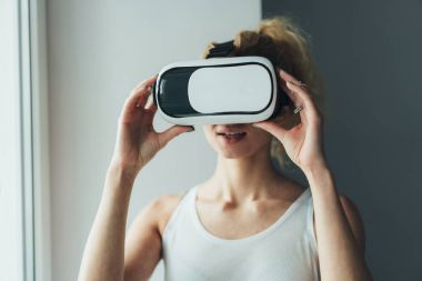 VR kulaklıklı kadın yukarı bakıyor.
