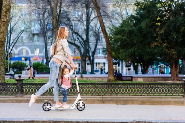 Moeder en dochtertje op een scooter — Stockfoto