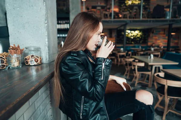 Красивая девушка в черной куртке в кафе — стоковое фото