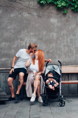 Anne, baba ve çocuk arabası içinde küçük oğlu