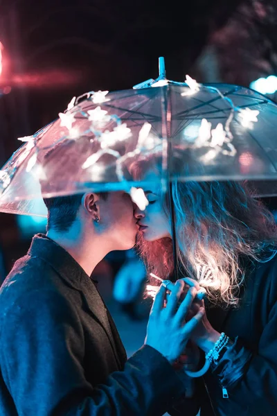 Kille och flicka kyssas under ett paraply — Stockfoto