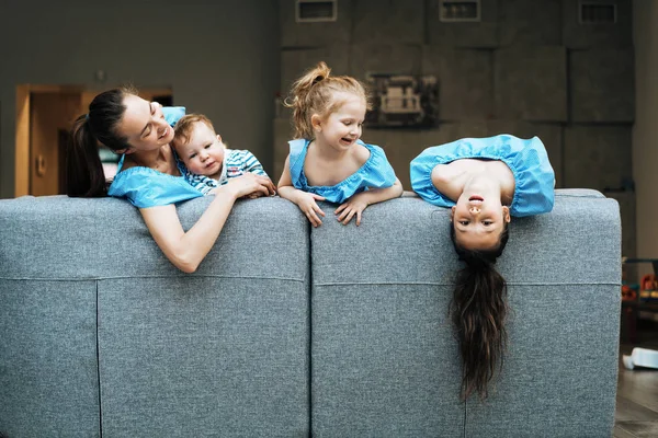 Mamma, två döttrar och en liten son på soffan. — Stockfoto