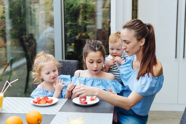 Two sisters drink juice in the kitchen — Stock Photo, Image