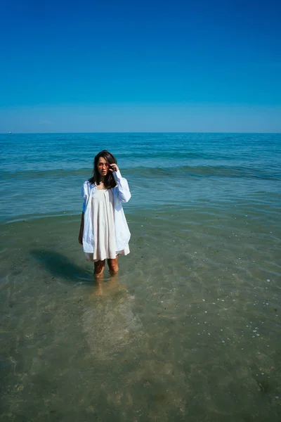 A rapariga está no mar junto à costa. — Fotografia de Stock